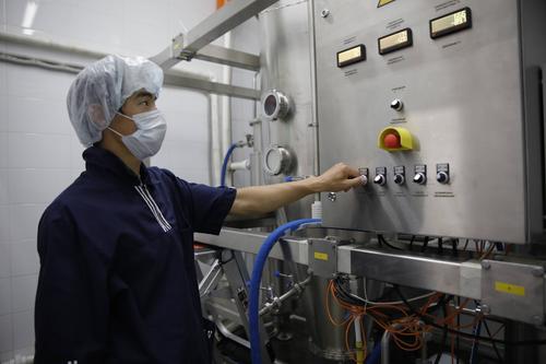 6月11日,哈萨克斯坦卡拉干达州一家乳品厂的工作人员操作奶粉生产设备
